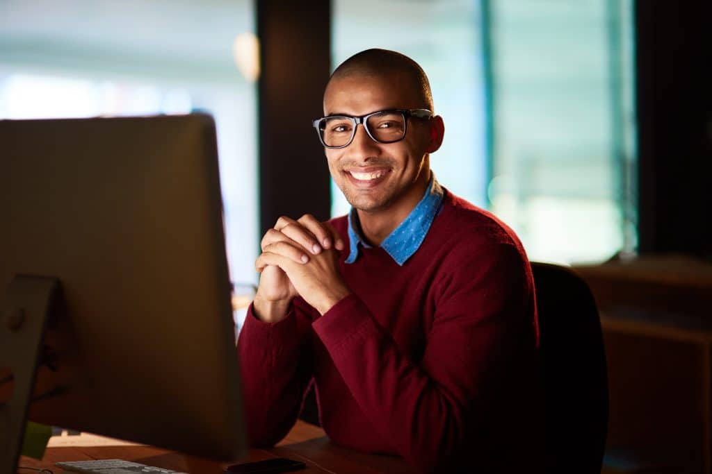 Smiling male employee working at home on computer