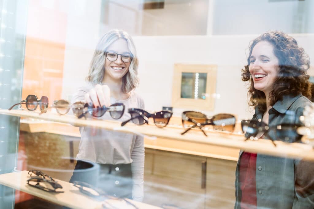 Female customers browsing eyewear merchandise inside an sunglasses store