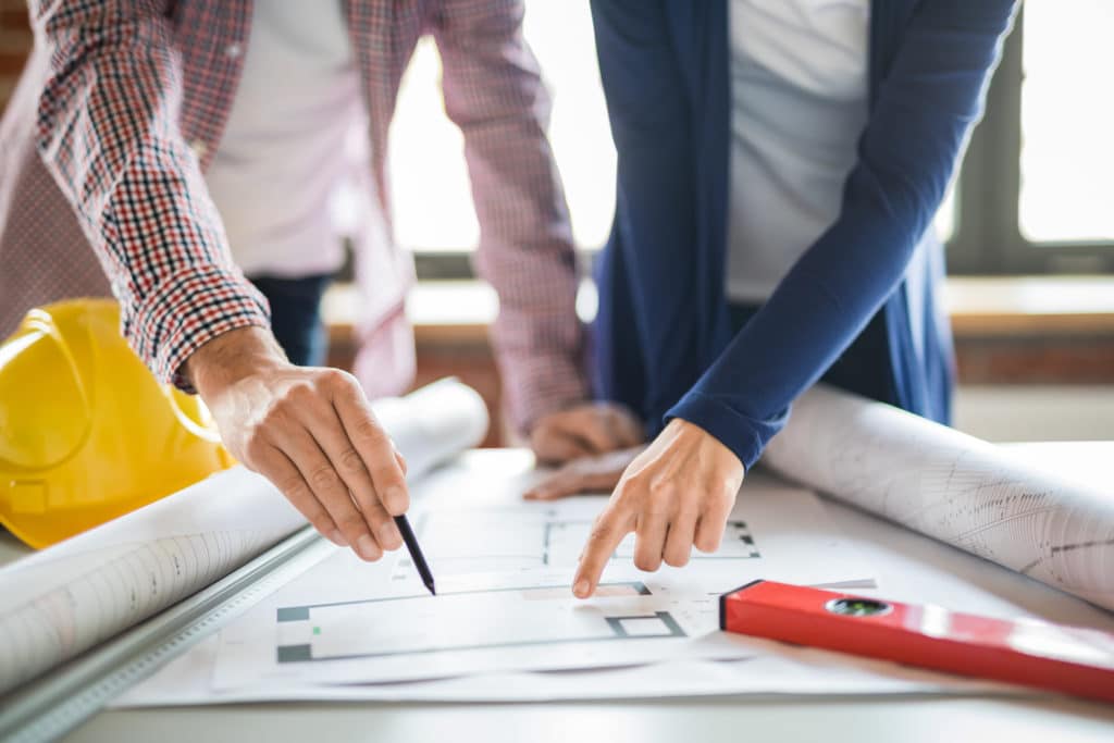 People reviewing blueprint of an office design