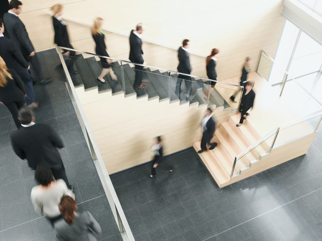 Line of office employees walking out of building 