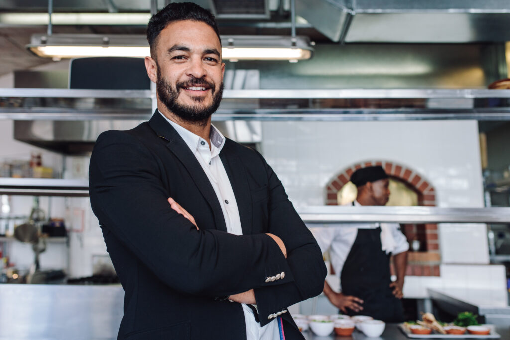 Male restauranteur standing in front of his kitchen preparing seasonal ingredients