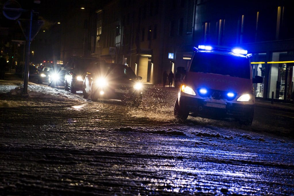 Ambulances driving in a city at night on icy streets in the winter