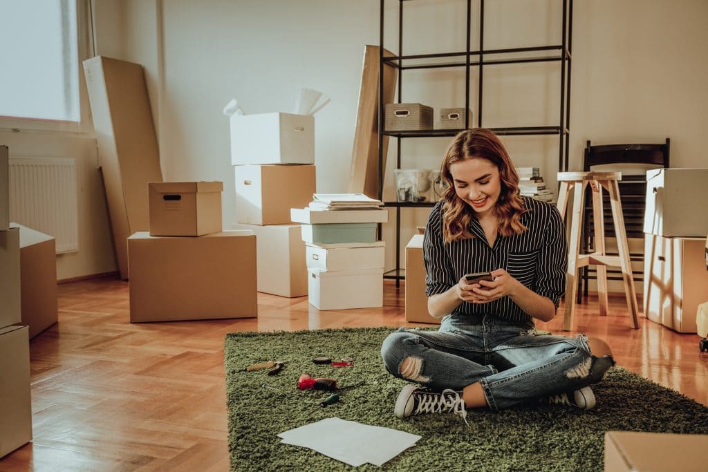 Young female surrounded by moving boxes in an apartment