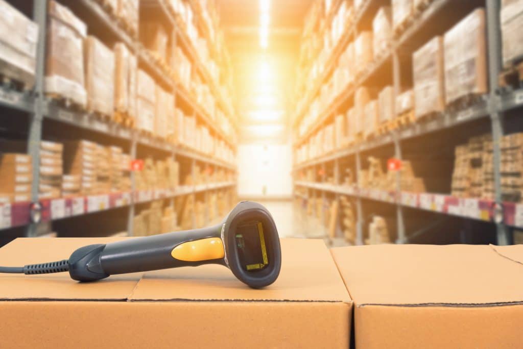 A barcode scanner laying on a box in a warehouse of medical supplies