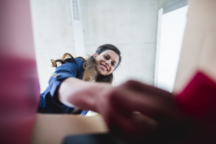 A female employee placing items in a box for a move