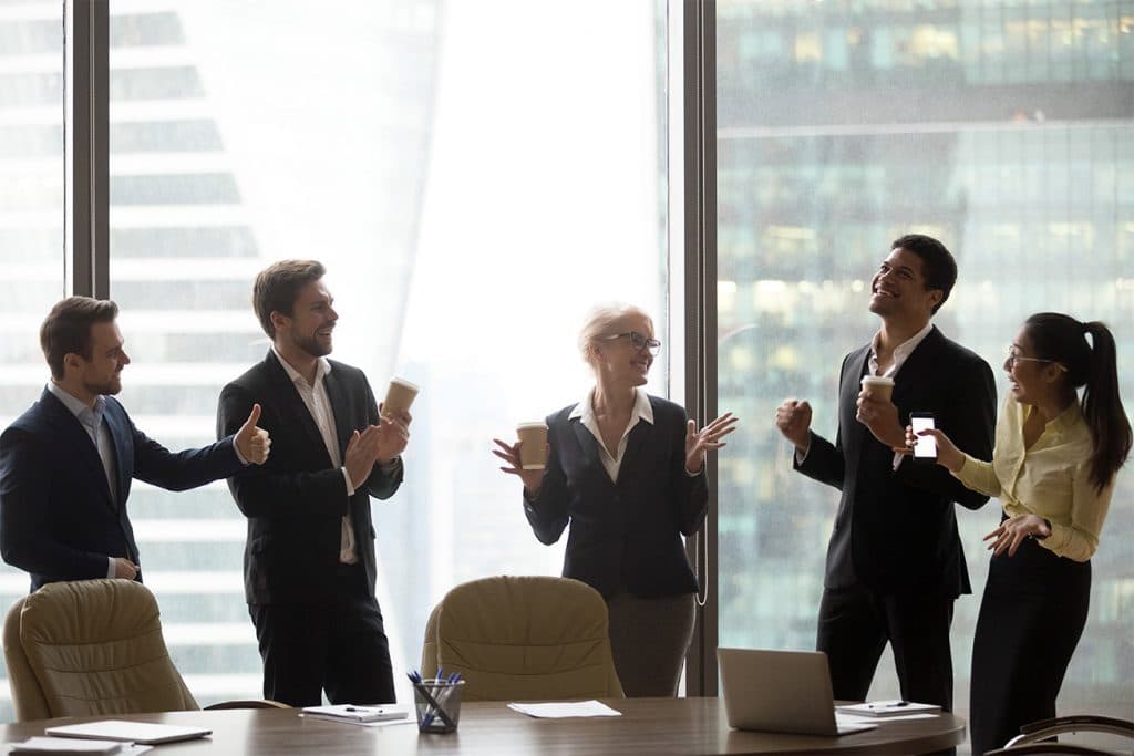 A group of employees visiting with a new hire inside an office