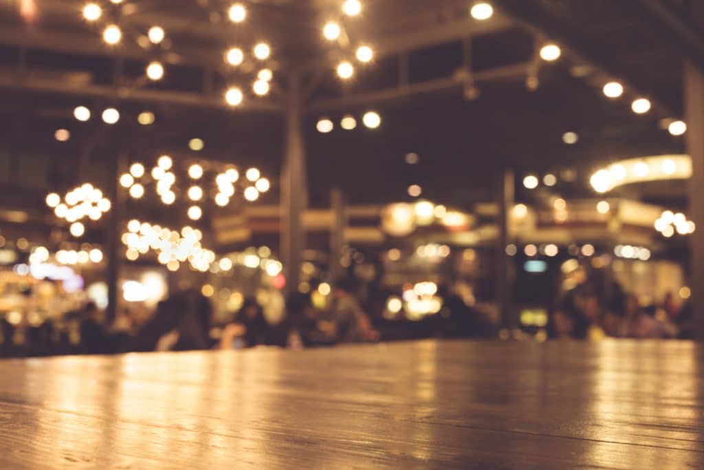 A busy restaurant patio with strong lights at night time