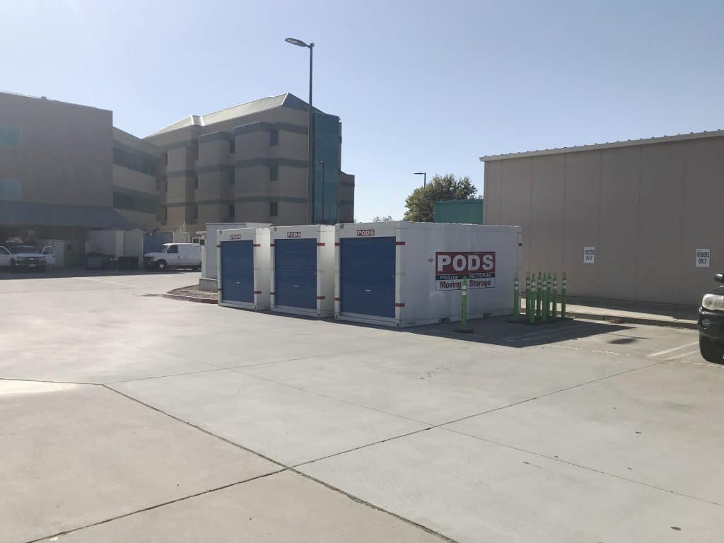 Three PODS containers sitting in a parking lot for hospital renovations