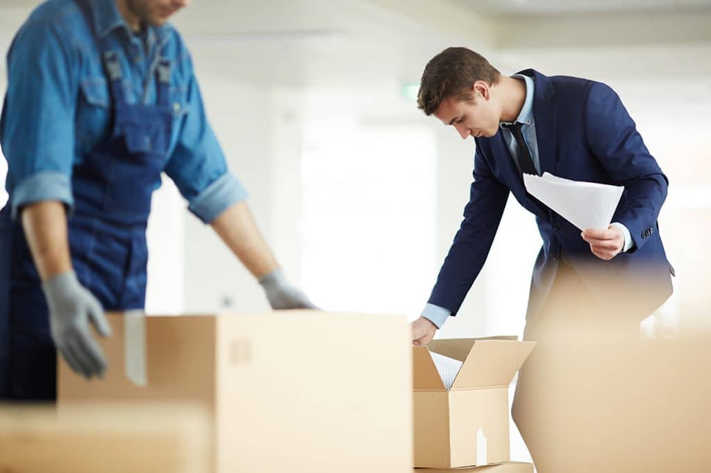 A full service mover and an employee packing boxes