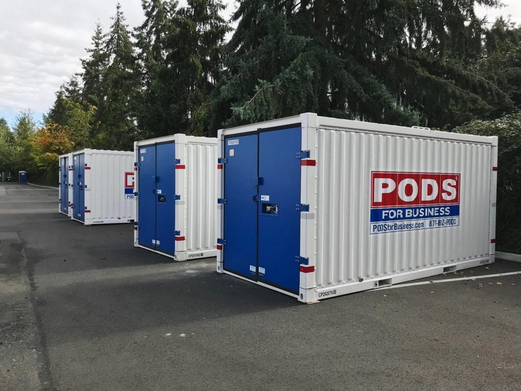 Three PODS shipping containers sitting in an empty parking lot