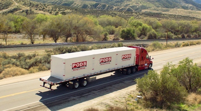 A PODS truck driving on a highway