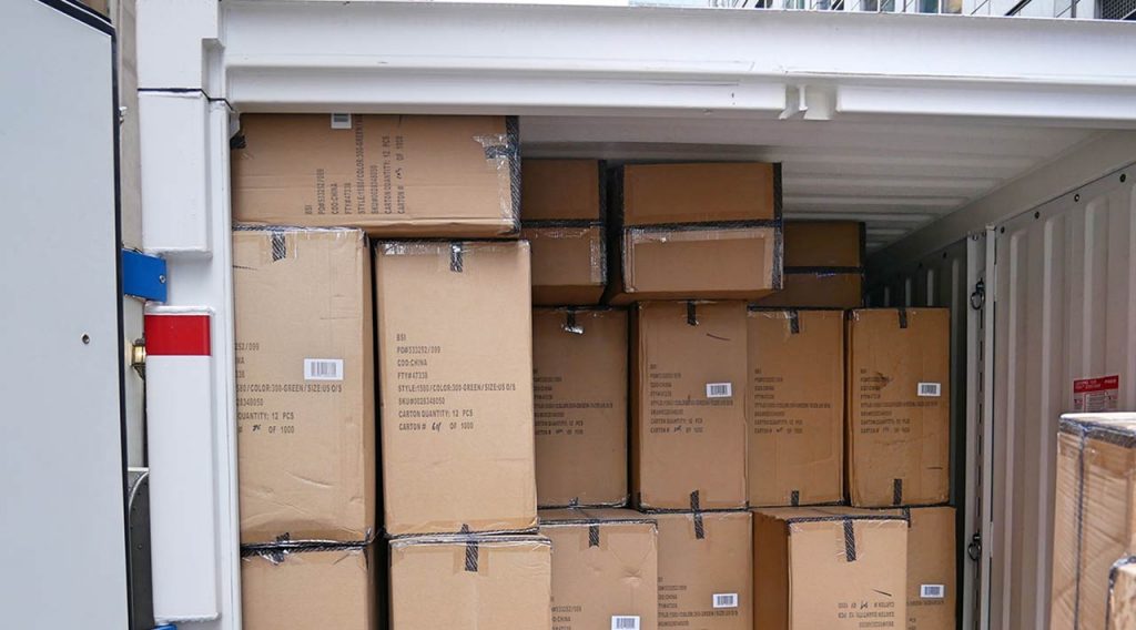 Stacks of boxes filled with emergency supplies inside a PODS container