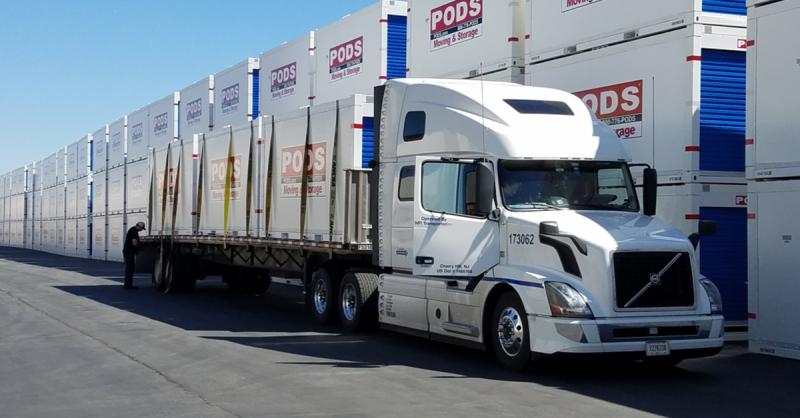 A parked semi truck loaded with three PODS containers