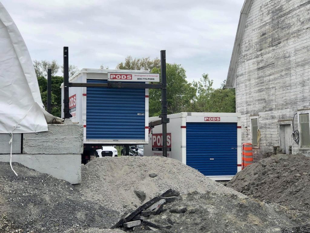 Two PODS containers being placed on a construction site