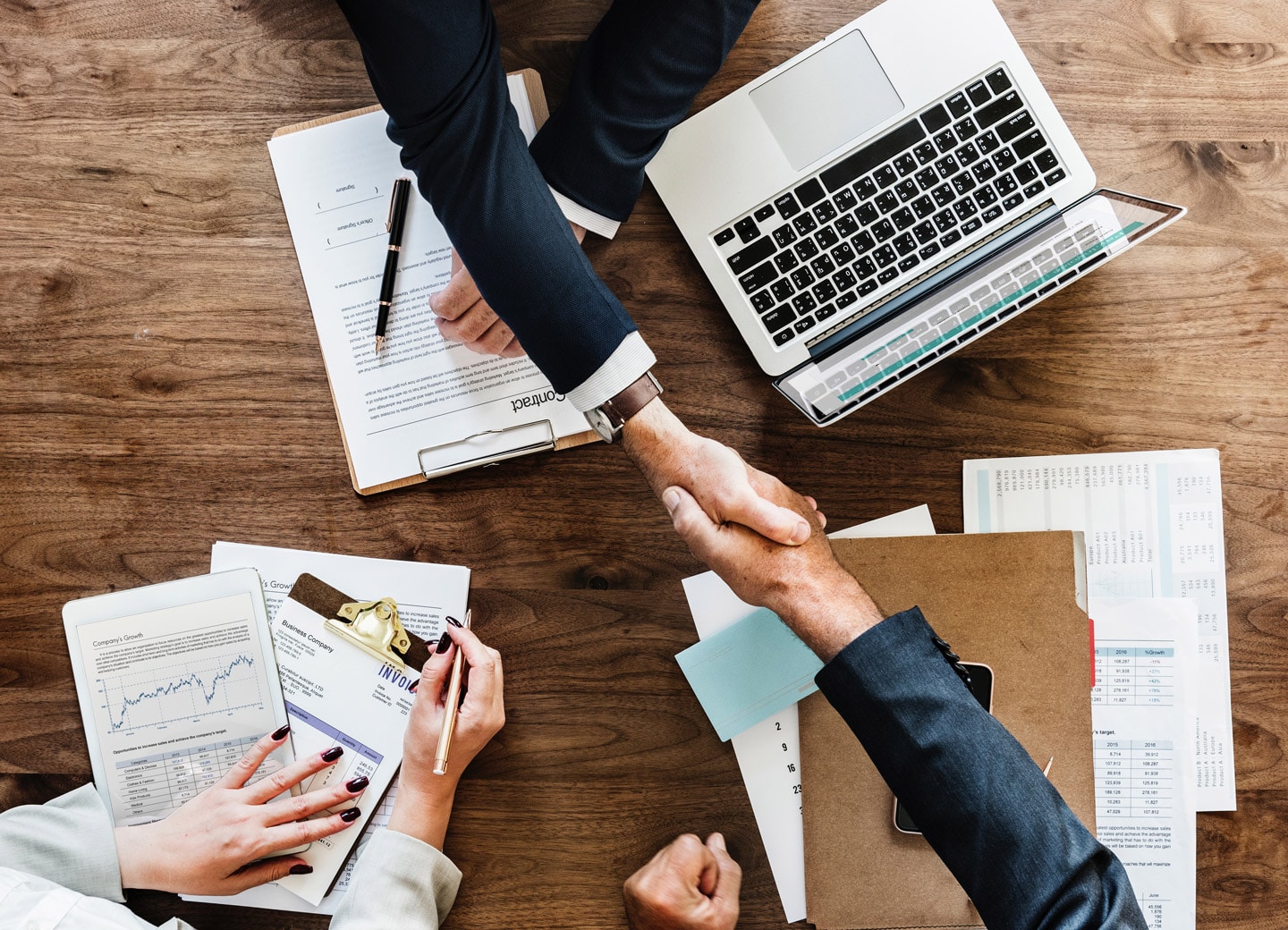 Office workers shaking hands over a table