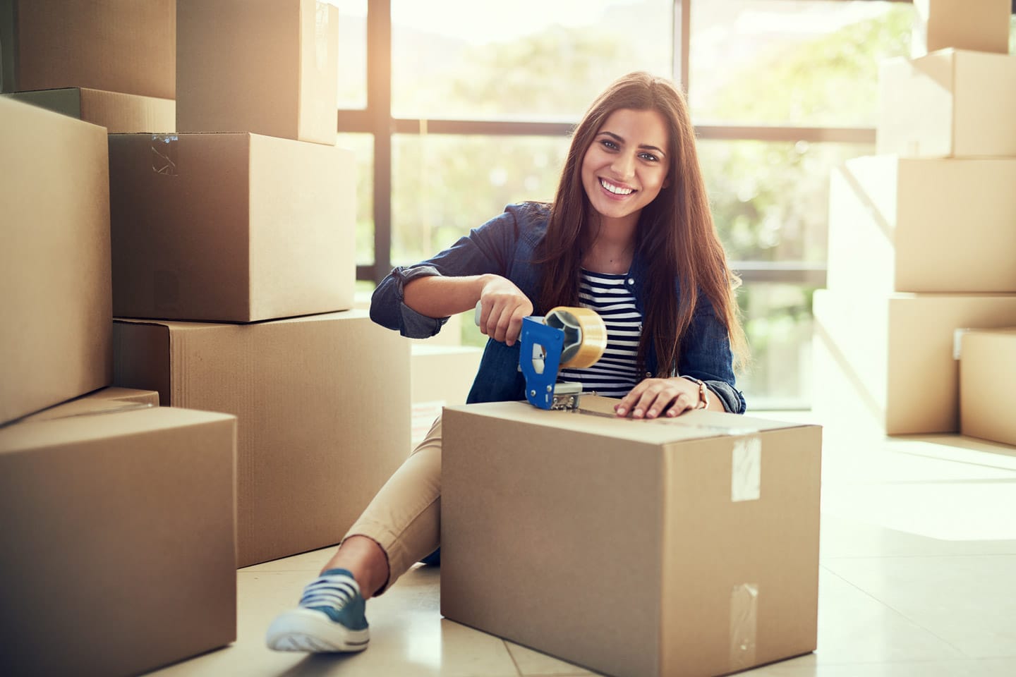 Woman packing moving boxes for employee relocation