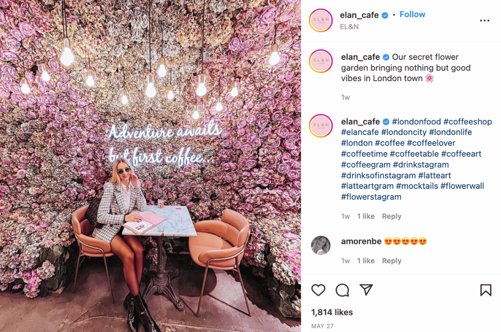 Woman sitting at a restaurant table with an Instagram wall backdrop
