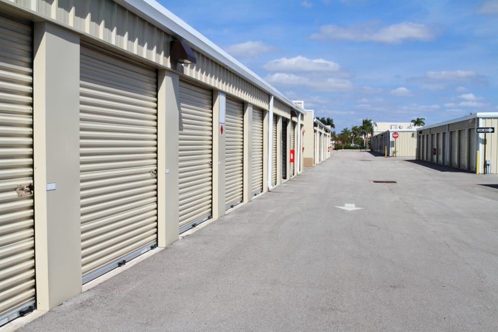 Warehouse building with storage units. Self storage facility. Row of metal roll up doors on self storage facility. 