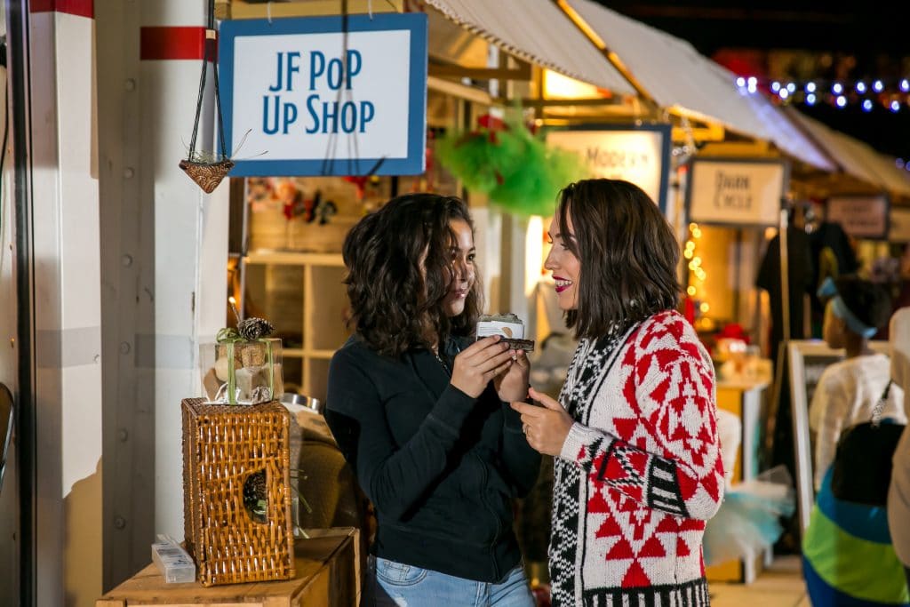 Two people standing in front of a contianer at Tampa Winter Village