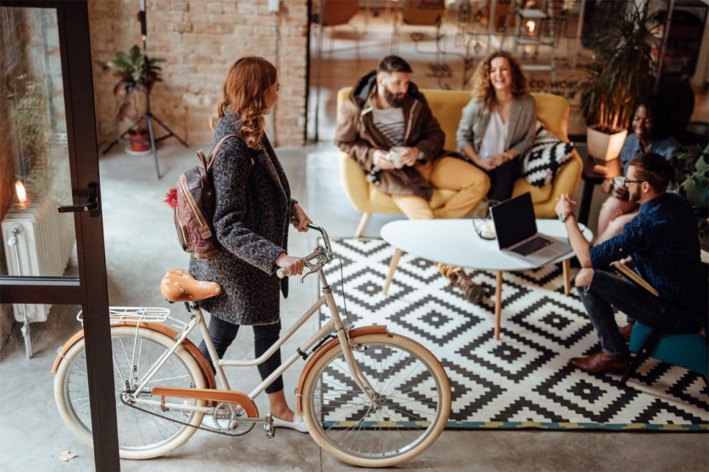 Young woman entering the inside of a busy co-working space