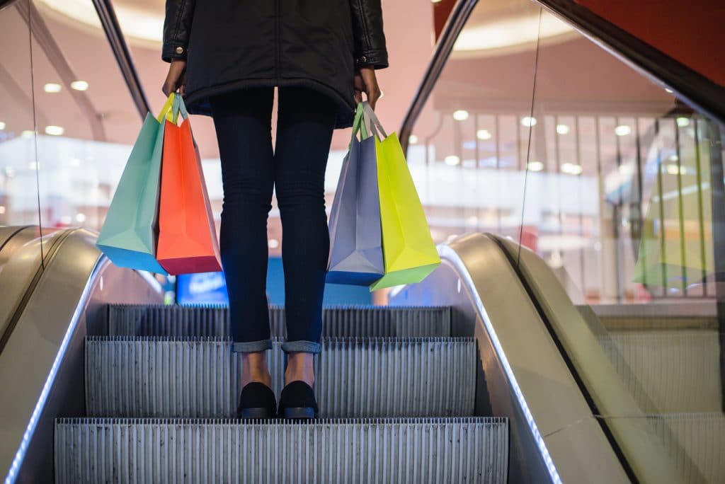 Woman holding bags on a shopping mall escalator