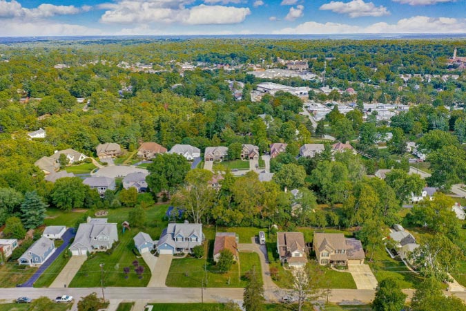 Aerial view of Madeira, Ohio, featuring distinct residential homes with lush green yards separated by bunches of mature trees.
