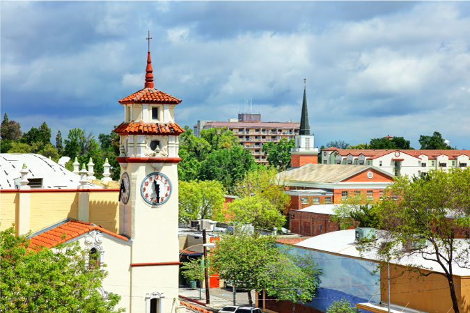 Rooftop view of Visalia, California, featuring a clock tower and church steeple