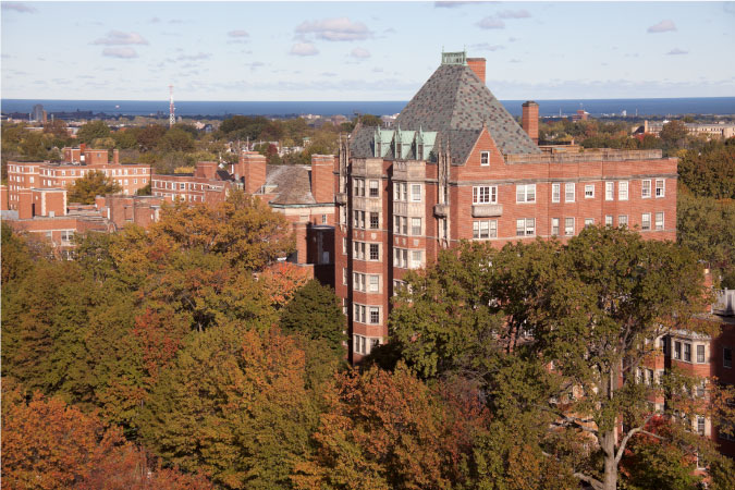 Historic red brick residential buildings peak out from autumn foliage in the Shaker Heights suburb of Cleveland, Ohio.