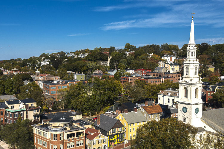 Aerial view of residential homes and a white church steeple in the College Hill Historic District of Providence, Rhode Island. 