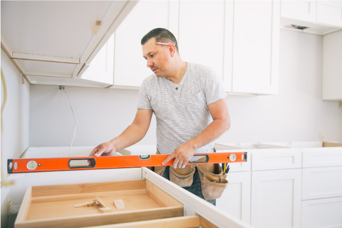 A professional contractor is using a level while installing new kitchen countertops