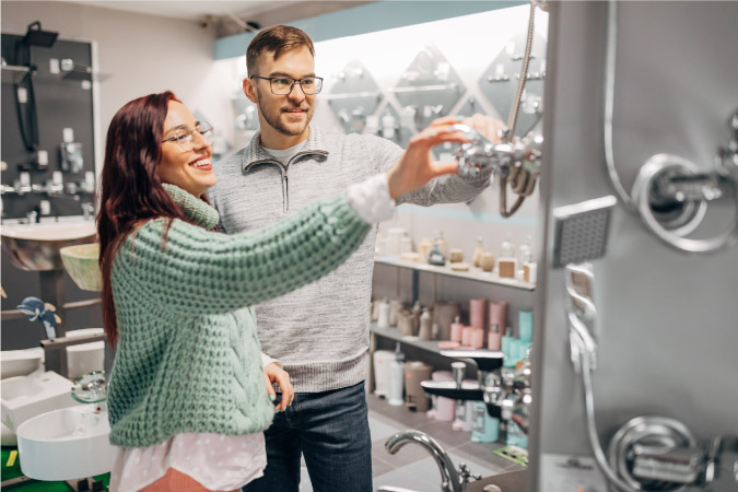 A couple is in a home improvement store, looking at bathroom fixtures