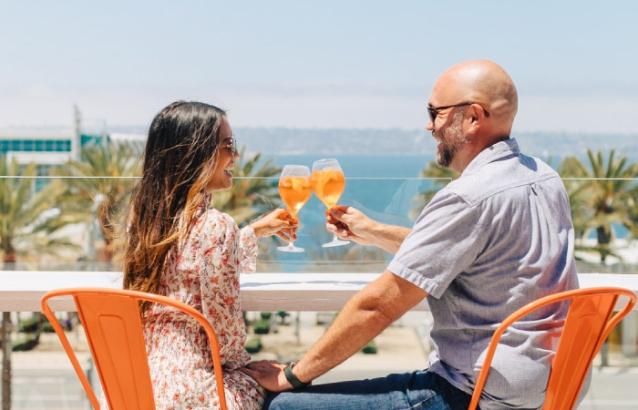 A couple enjoys a refreshing wine spritzer while dining al fresco in San Diego on a beautiful summer day.
