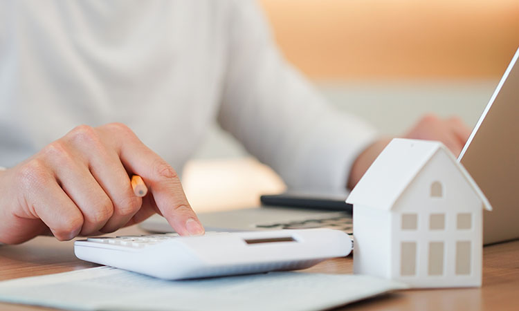 A man using a calculator to determine his loan repayment plan