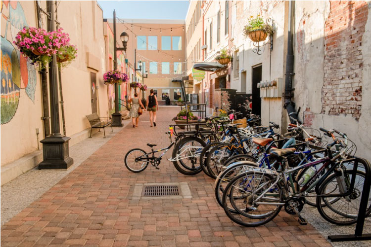 Two women walk down a quaint pedestrian street in Fort Collins, Colorado, after locking up their bicycles with a dozen others. 