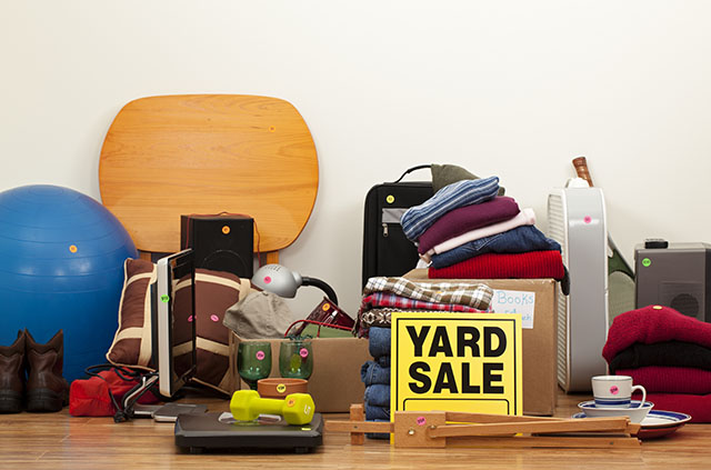 A collection of various items have had colorful price tags stuck to them so they can be sold during garage sale season