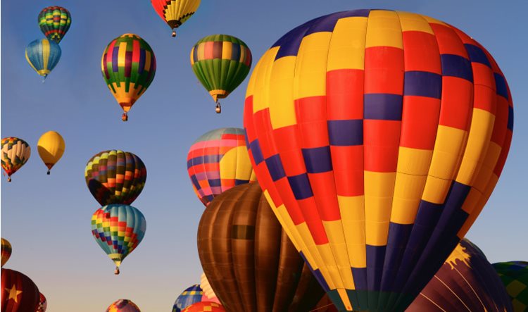 Hot air balloons in a myriad of colors begin their ascent into the early morning skies near Albuquerque, New Mexico, during the city’s annual Balloon Fiesta.