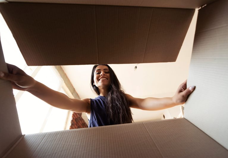 A woman looks into a box, readying it to be packed