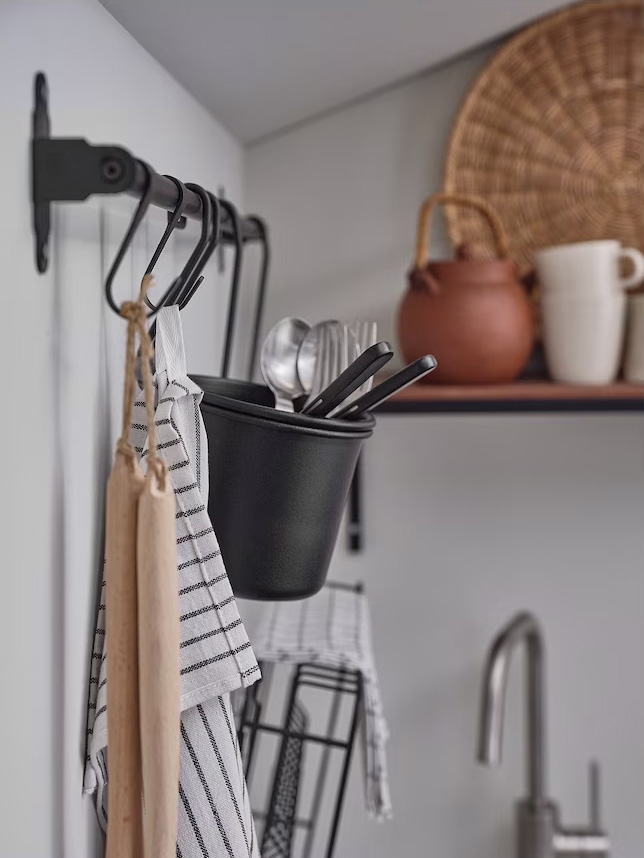 Hanging hooks in the kitchen, holding towels, silverware, and aprons