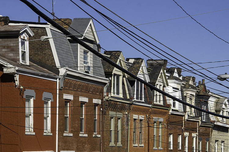 A row of brick houses framed by wires in the Lawrenceville neighborhood of Pittsburgh, PA.