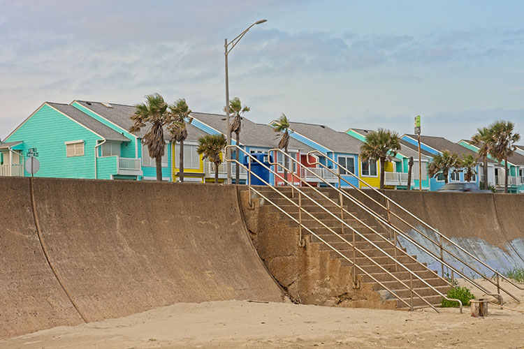 Colorful beach homes behind the Galveston sea wall on a windy day.
