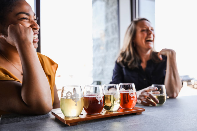 Two women laugh together while enjoying a tasting of craft beers and mead at a brewery in Lexington, Kentucky.