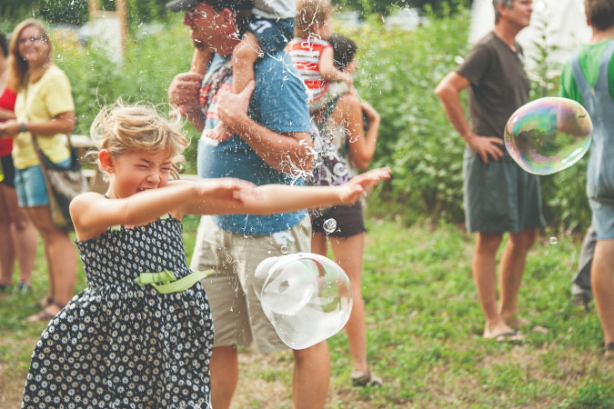 A young girl reacts to a bubble popping on her arm during a community event in Lincoln, Nebraska.