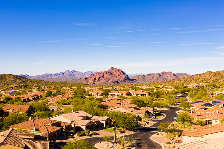 A residential Mesa neighborhood with red desert bluffs visible in the distance. 