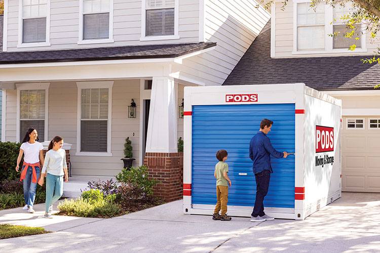 A family of four is about to open the blue door on their PODS portable moving container, as they prepare to load it up for their move to Omaha, Nebraska.