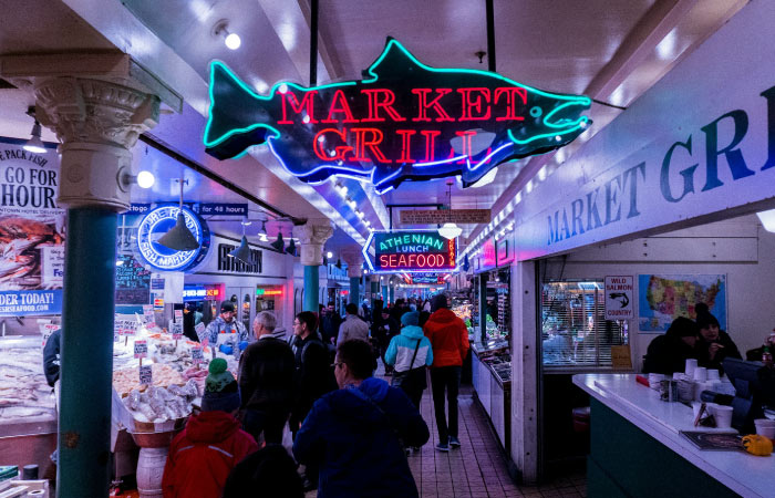 People browse an indoor food market in Seattle, Washington.