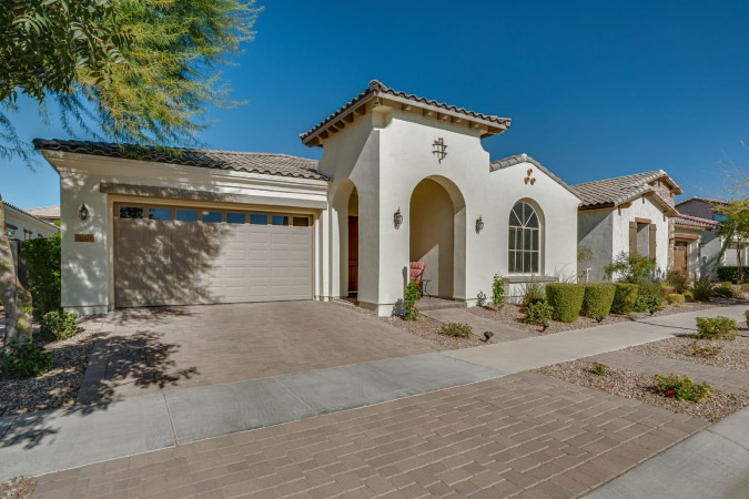 A large stucco home in the Eastmark neighborhood of Mesa, Arizona, featuring a tall covered entryway.