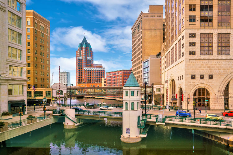 View of a bridge and surrounding skyscrapers in Downtown Milwaukee, Wisconsin, on a sunny day.