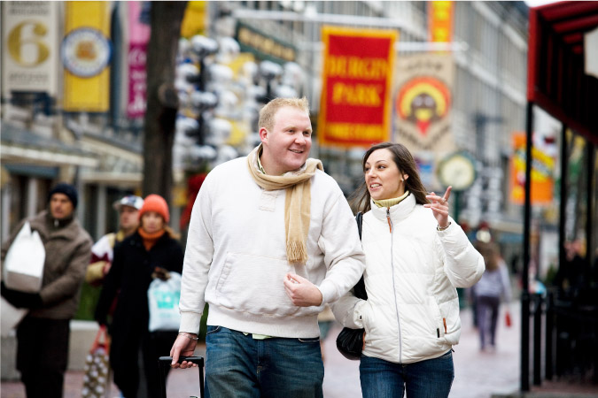 A couple of Bostonians converse as they walk through the city on a chilly afternoon.