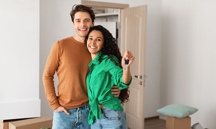 A happy young couple showing the keys to their next home