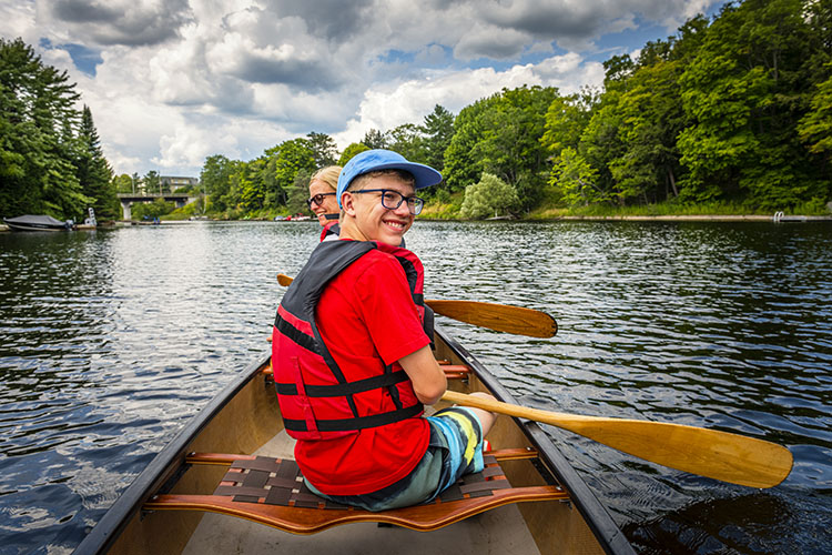 A mother and her son canoeing on Fairy Lake in Huntsville on a muggy summer’s day